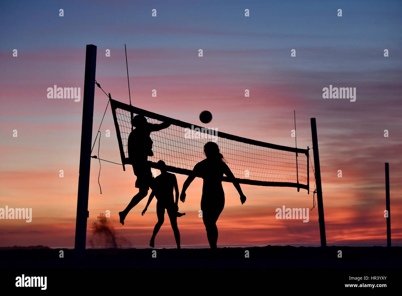 Sagome di pallavolo femminile giocatori praticare pallavolo sulla spiaggia al tramonto in Mission Beach, San Diego, California. Foto Stock