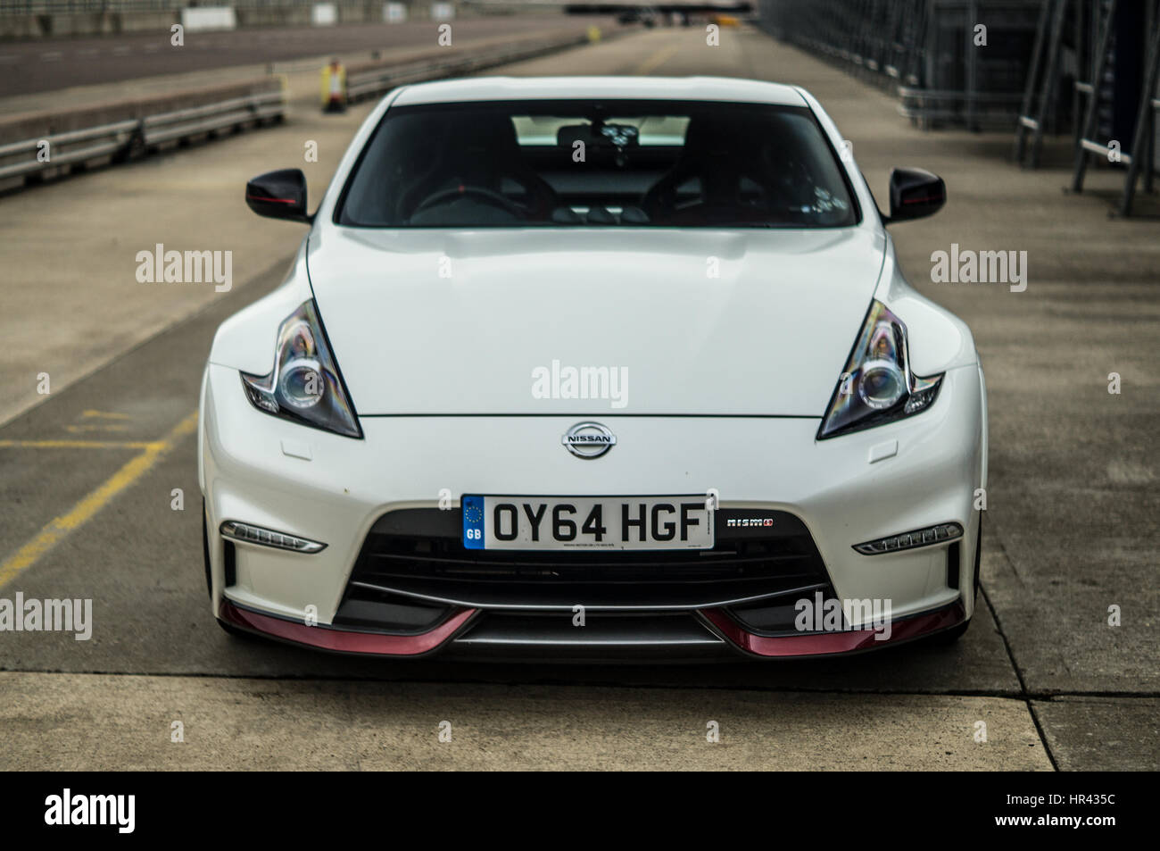 Anteriore, testa sul colpo di un bianco Nissan 370z Nismo su una pista, in pit lane. Foto Stock
