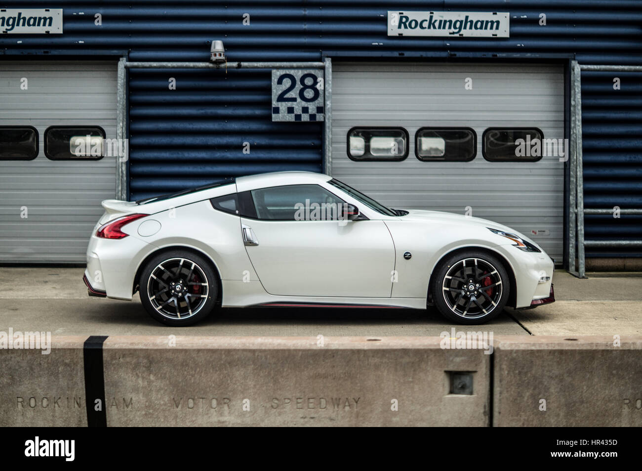 Profilo laterale di un bianco Nissan 370z Nismo su una pista, in pit lane. Foto Stock