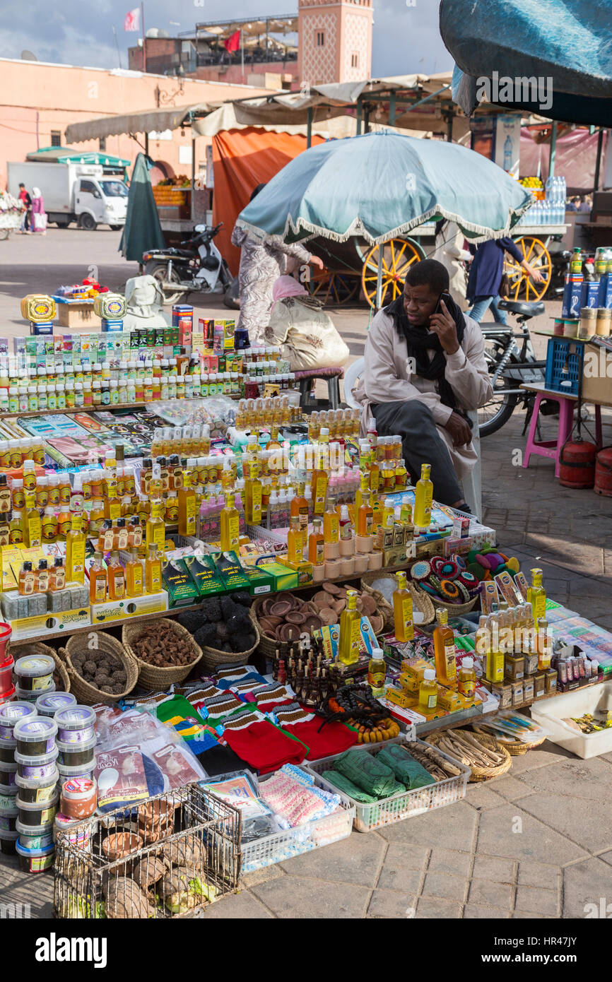 Marrakech, Marocco. Fornitore di olio di Argan e un assortimento di accessori personali, Piazza Jemaa El Fna. Foto Stock