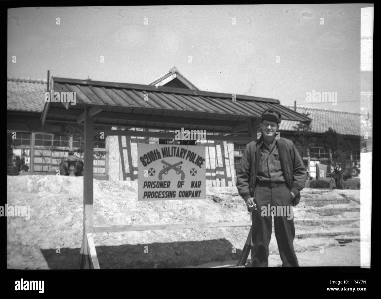 Soldato americano permanente sulla parte anteriore del segno per il 8210th Polizia Militare prigioniero di guerra Società di elaborazione nel 1950 durante la Guerra di Corea. Foto Stock