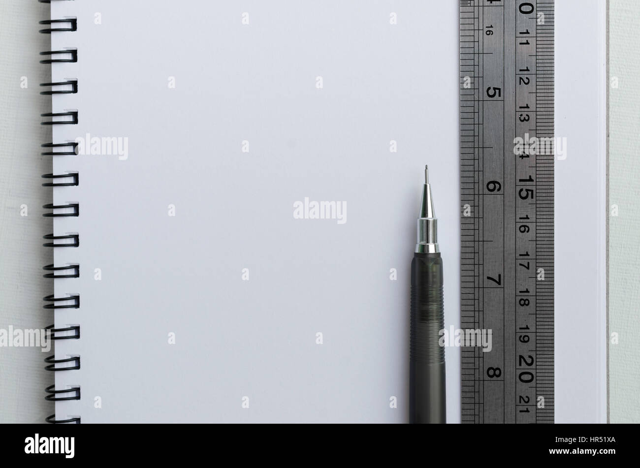 Blank white paper di wirebound notebook con matita meccanica e righello in acciaio inox. Foto Stock