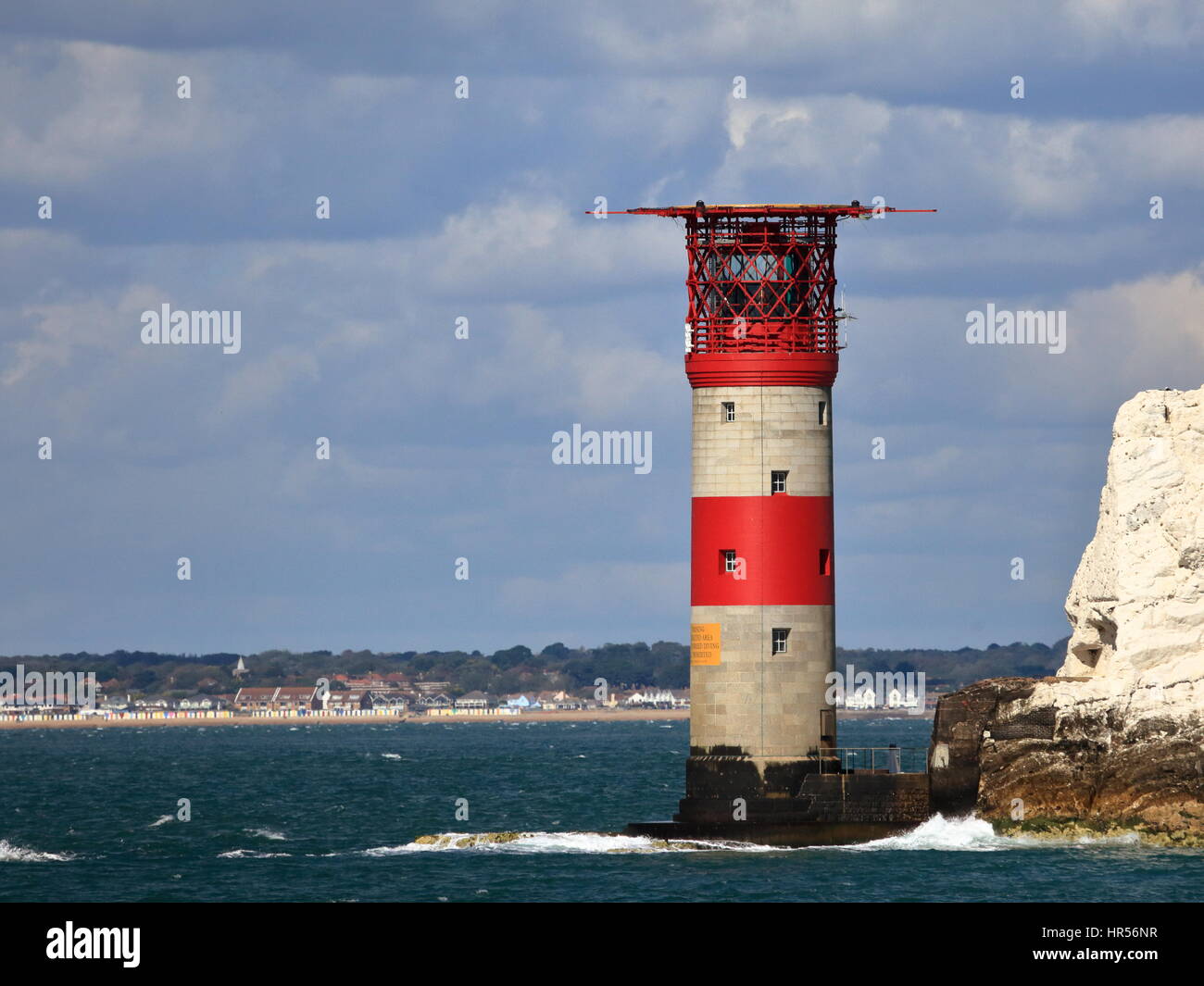 Imponente il bianco e il rosso Trinità Lighthouse ribaltamento della familiarità aghi pila di rocce landmark con sfondo della terraferma Hampshire REGNO UNITO Foto Stock