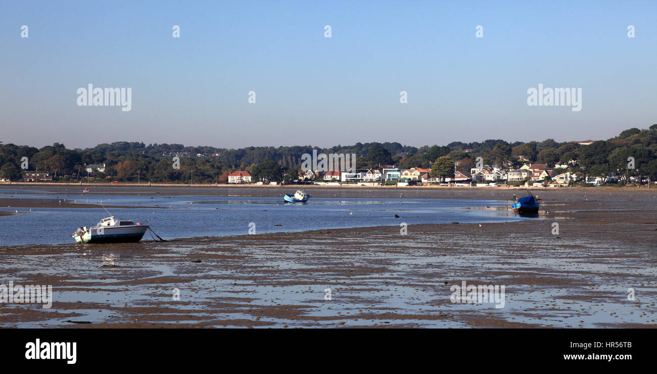 Acqua bassa nel porto di Poole lasciando barche ormeggiate sulla sabbia bagnata Foto Stock