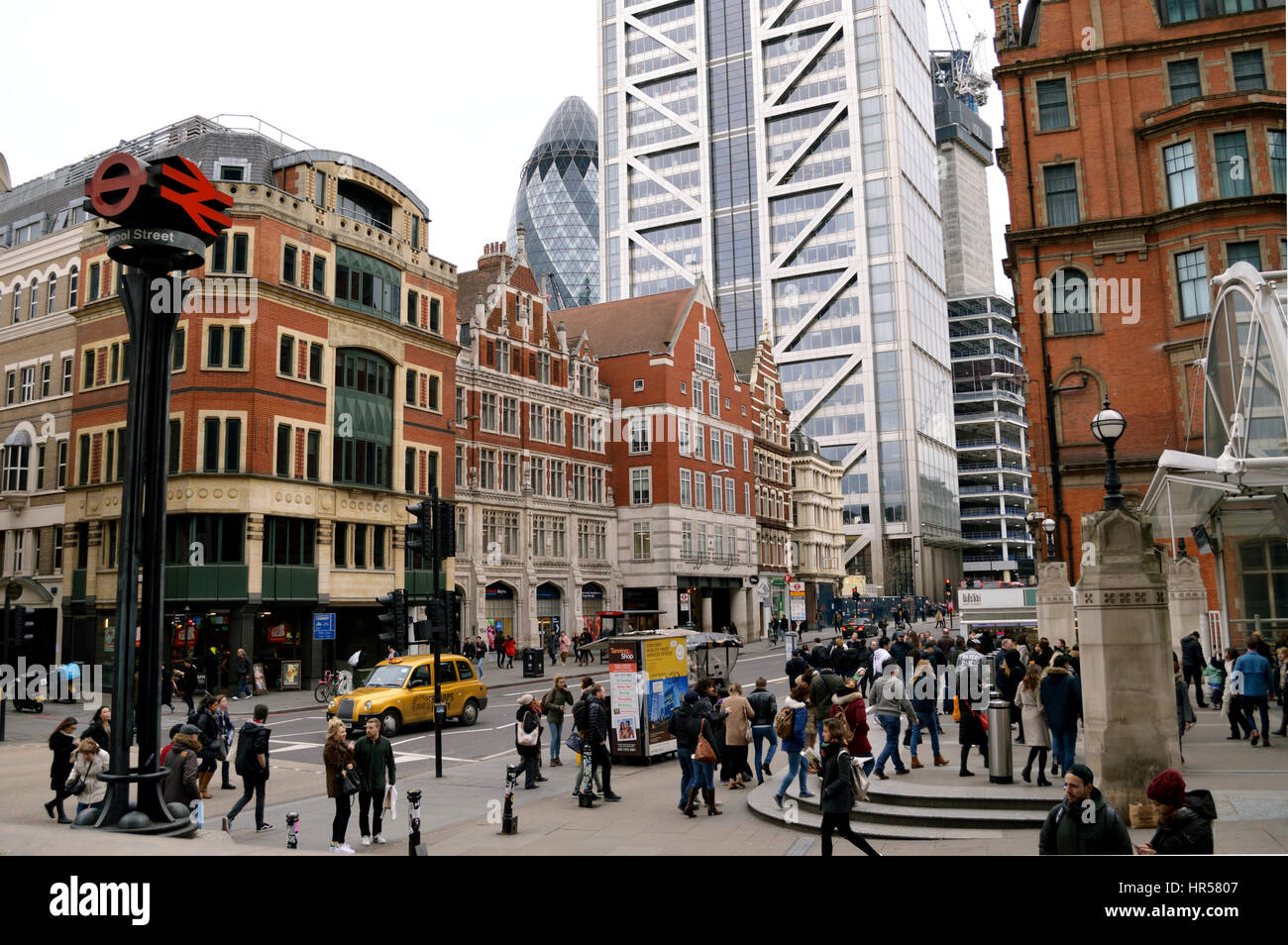 Architettura di contrasto come visto dal di fuori dalla stazione di Liverpool Street a Londra, Regno Unito, con la torre di airone e il Gherkin in background in 2017 Foto Stock