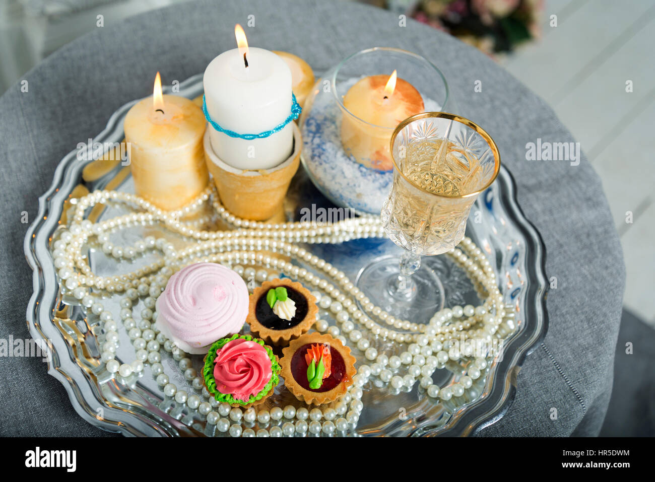 Candele, torta, perle su un piatto d'argento durante il matrimonio Foto  stock - Alamy