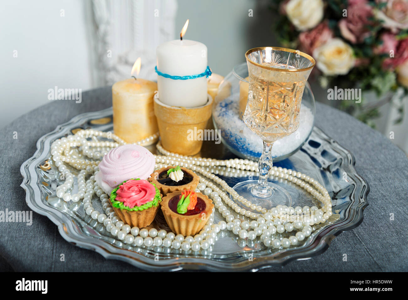 Candele, torta, perle su un piatto d'argento durante il matrimonio Foto  stock - Alamy