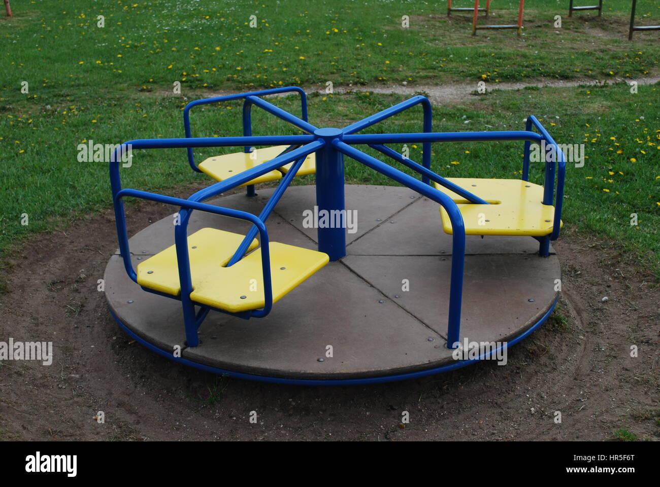 Tondo blu altalena per bambini con sedi di giallo in un parco pubblico. Foto Stock