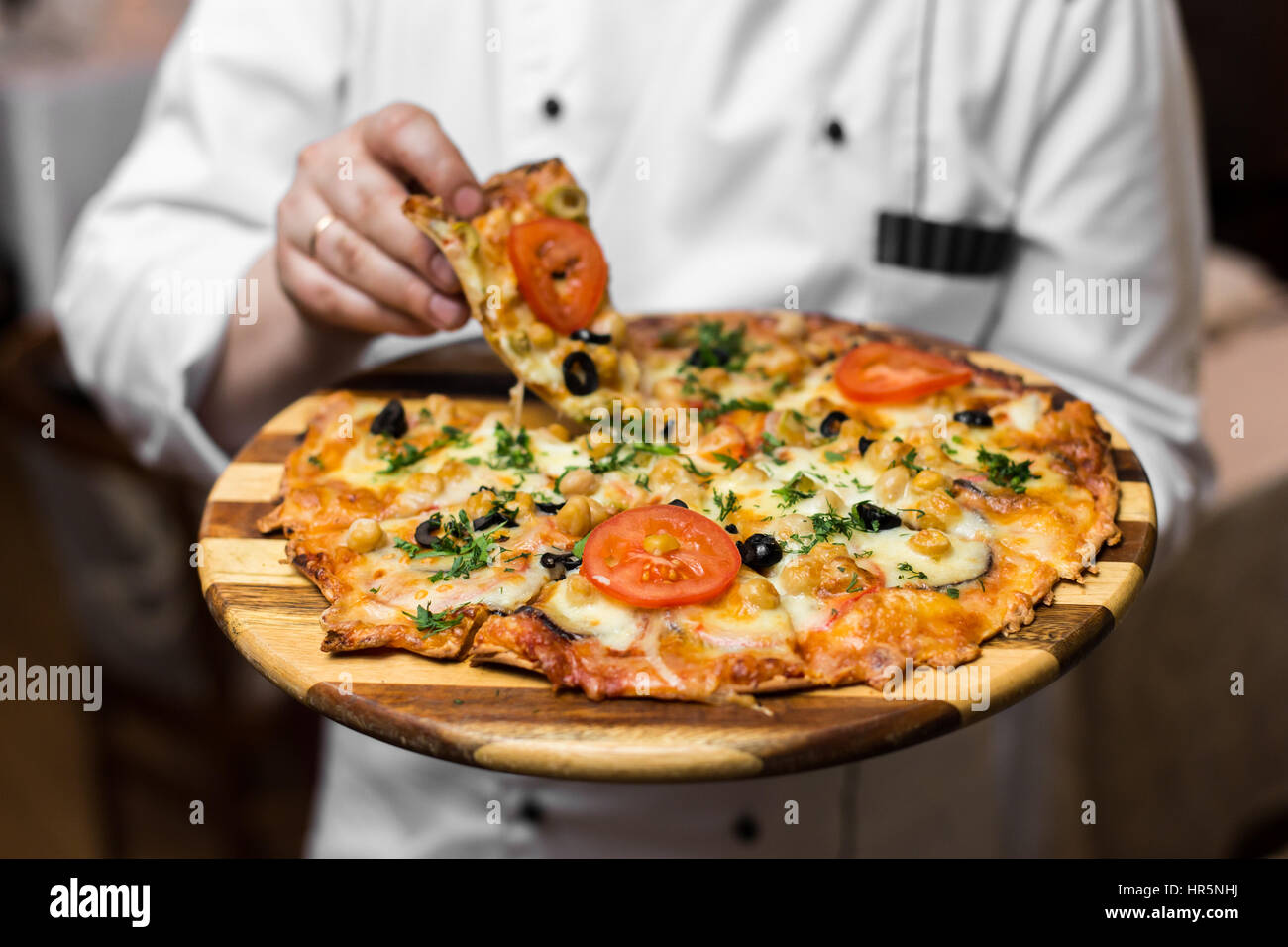 White a legna per pizza napoletana Maker Close Up tenendo il vassoio in argento con torta fresca Foto Stock