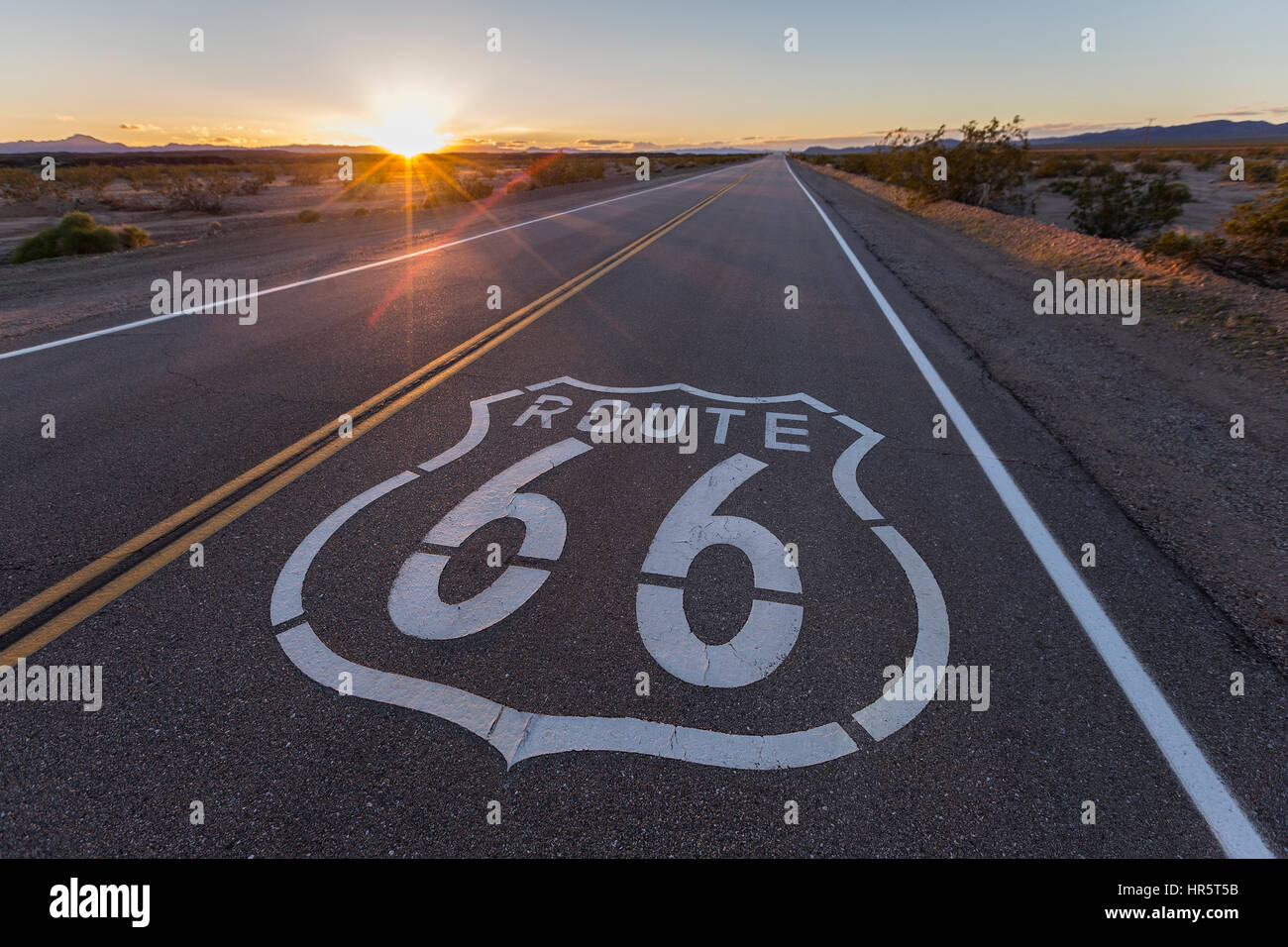 Route 66 autostrada segno tramonto in California Mojave Desert. Foto Stock