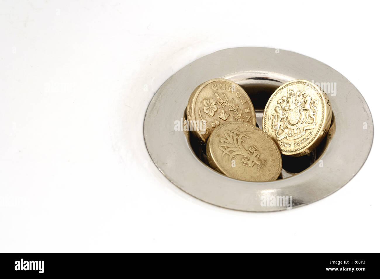 Tre British pound monete bloccato in un pozzo di scarico di un lotto o lavello. Foto Stock