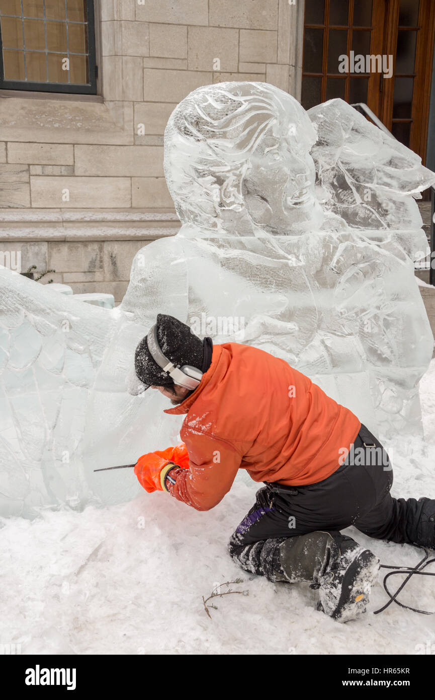 Montreal, CA - 4 Febbraio 2017: ghiaccio scultore carving un blocco di ghiaccio durante la Frima " Fête des glacés' su Saint-Denis street. Foto Stock