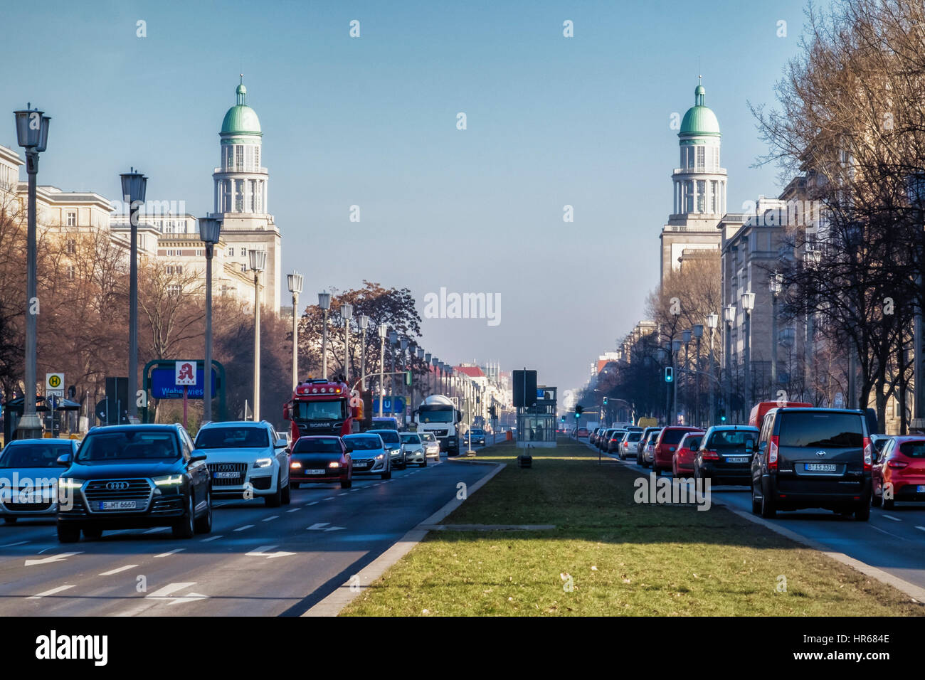 Berlin Friedrichshain,il traffico nella strada trafficata, Karl Marx Allee e le torri gemelle di elencati Frankfurter Tor (Gate) edificio. Foto Stock