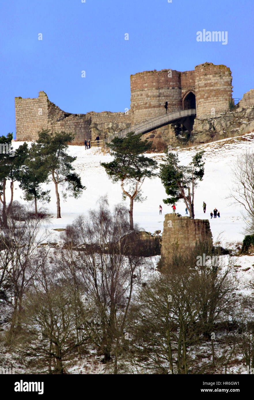 13th ° secolo Beeston Castello Cheshire in piedi sul sentiero di arenaria visto in inverno con cielo blu e visitatori a piedi e giocare nella neve Foto Stock