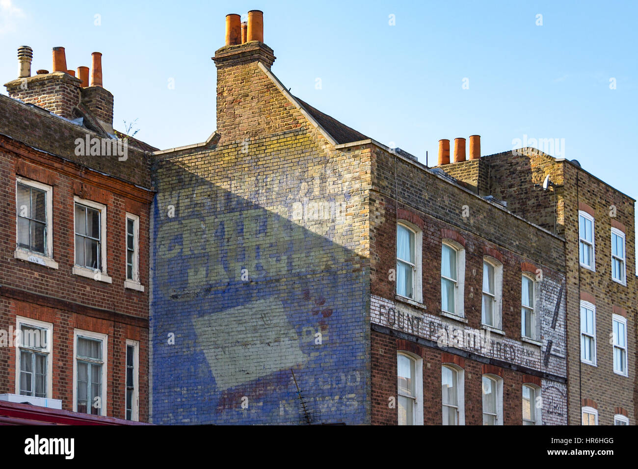 Un vecchio sbiadito pubblicità sul lato di un edificio a Stoke Newington, Londra Foto Stock