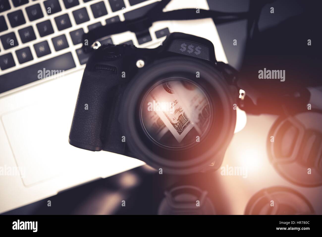 Fotografia Microstock Concetto aziendale foto con una fotocamera digitale e di banconote del dollaro di riflessione all'interno della lente e il computer portatile. Fare Soldi prendendo P Foto Stock