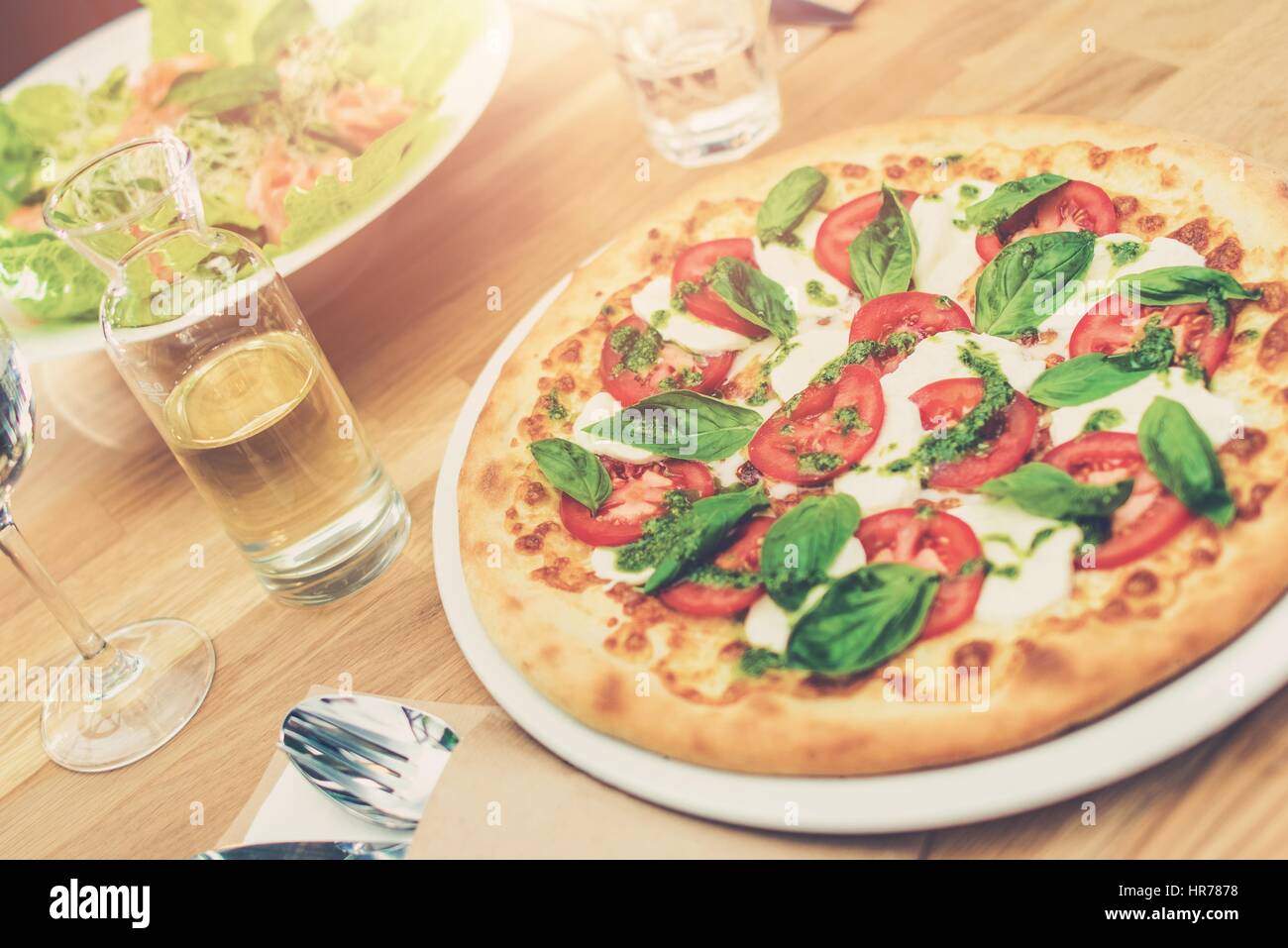 Di gusto al pomodoro e basilico sulla pizza il ristorante in legno Tavolo. Foto Stock