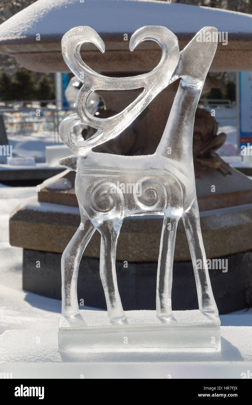 Sculture di ghiaccio a Ottawa, in una giornata di sole con city park dietro. Il ghiaccio scupltrure è di renne con la sua testa tesa fino e palchi all'indietro. Foto Stock