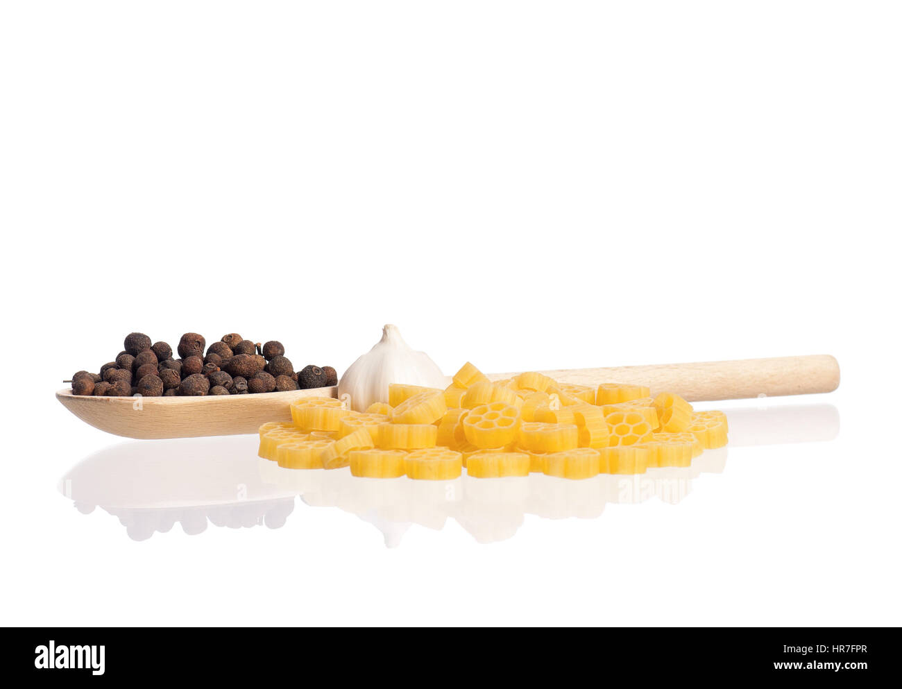 La pasta con il cucchiaio di legno e di spezie, isolati su sfondo bianco Foto Stock