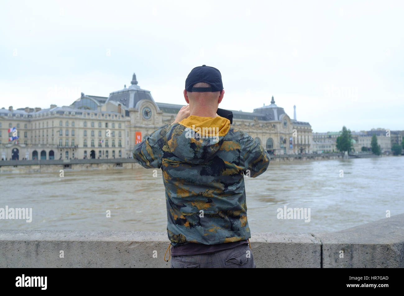 Un ragazzo di scattare una foto con la traboccante fiume Senna a Parigi con il suo smartphone Foto Stock