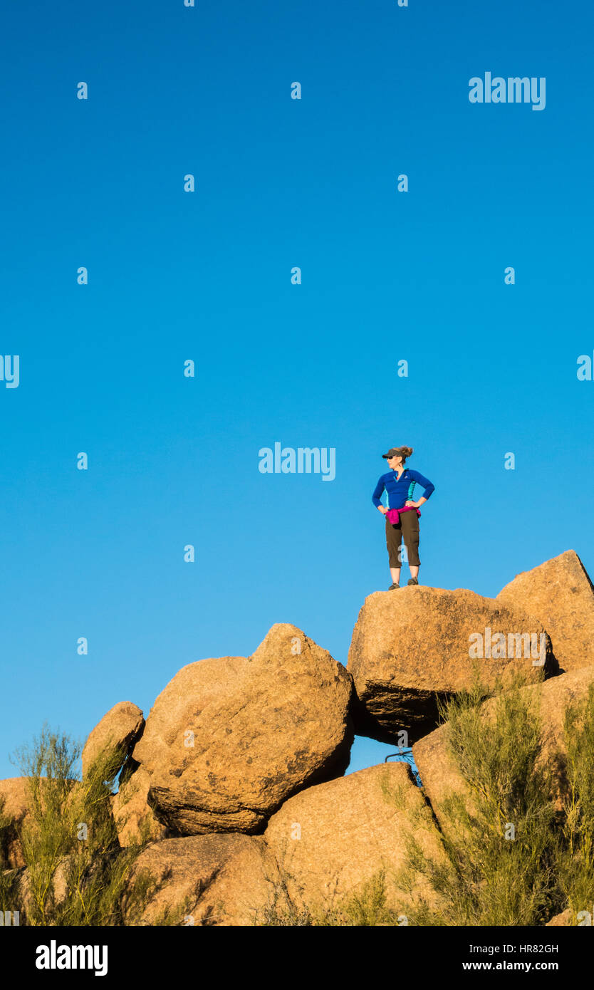 Una donna in piedi su alcune rocce con cielo blu sopra. Picco Pinnacolo Park, Scottsdale, Arizona, Stati Uniti. Foto Stock