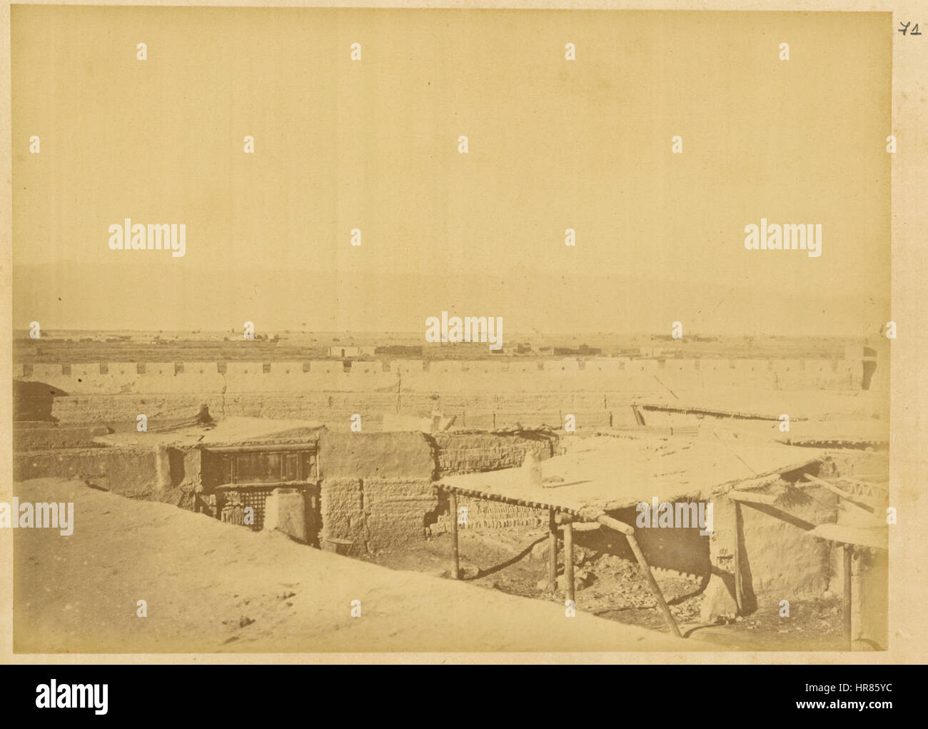 Questa fotografia storica del 1875 mostra la città di Gucheng nello Xinjiang, in Cina, dopo essere stata devastata dalle rivolte. Le montagne Tian Shan e Bogda Peak fungono da sfondo drammatico, illustrando l'aspro paesaggio della regione. Foto Stock