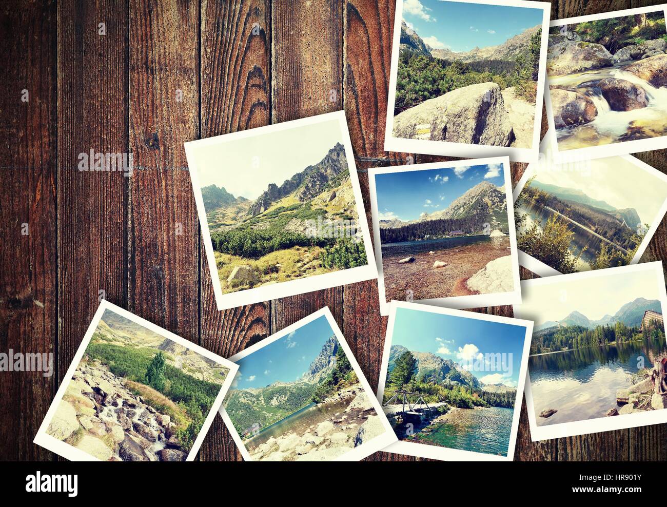 Mucchio di vintage foto dalle vacanze in montagna con un tradizionale telaio bianco posizionato sulla scrivania in legno. Foto Stock