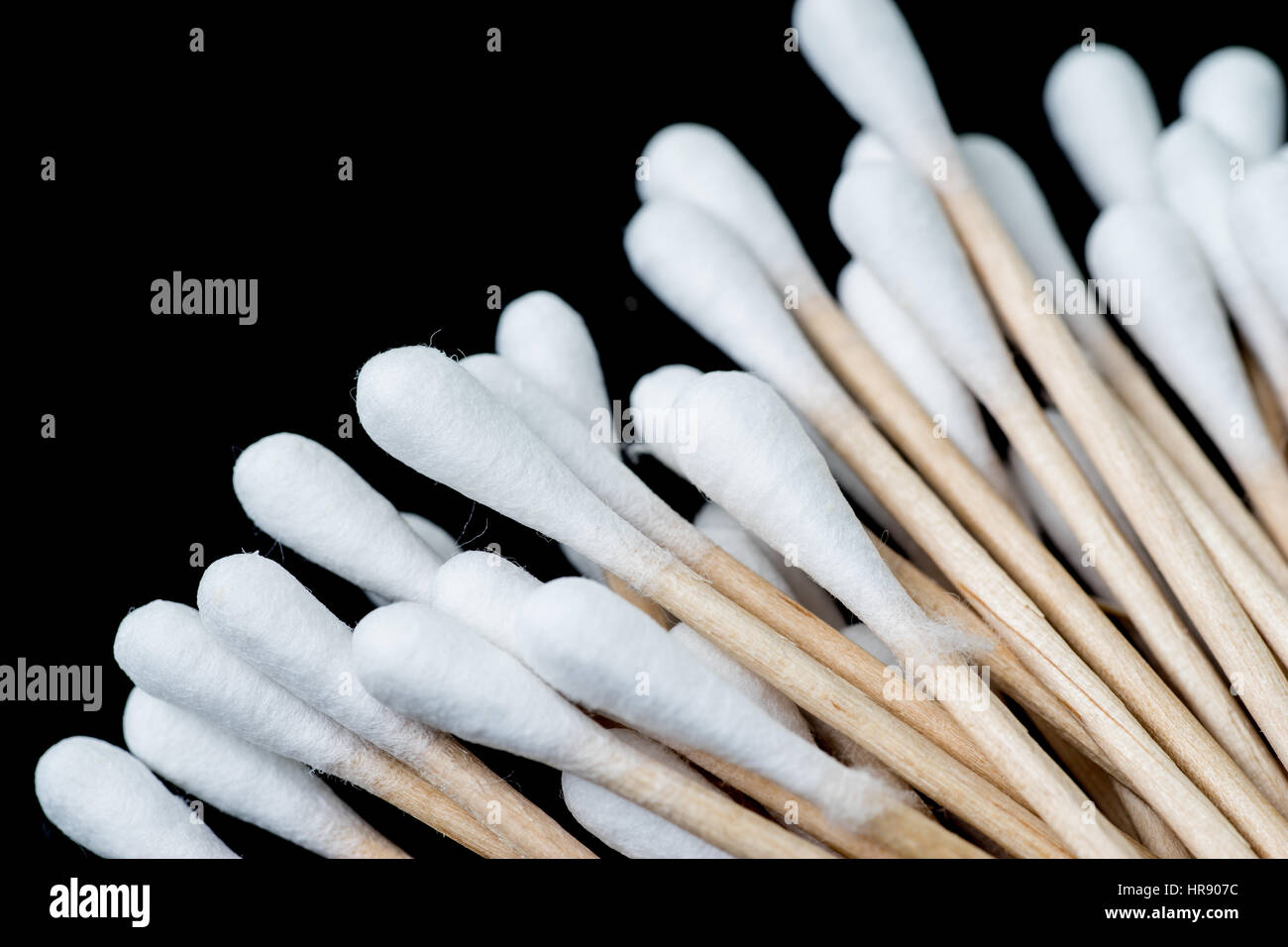 Pila di tamponi di cotone, q suggerimenti, distribuite a ventaglio. I tamponi sono fotografati contro uno sfondo nero Foto Stock