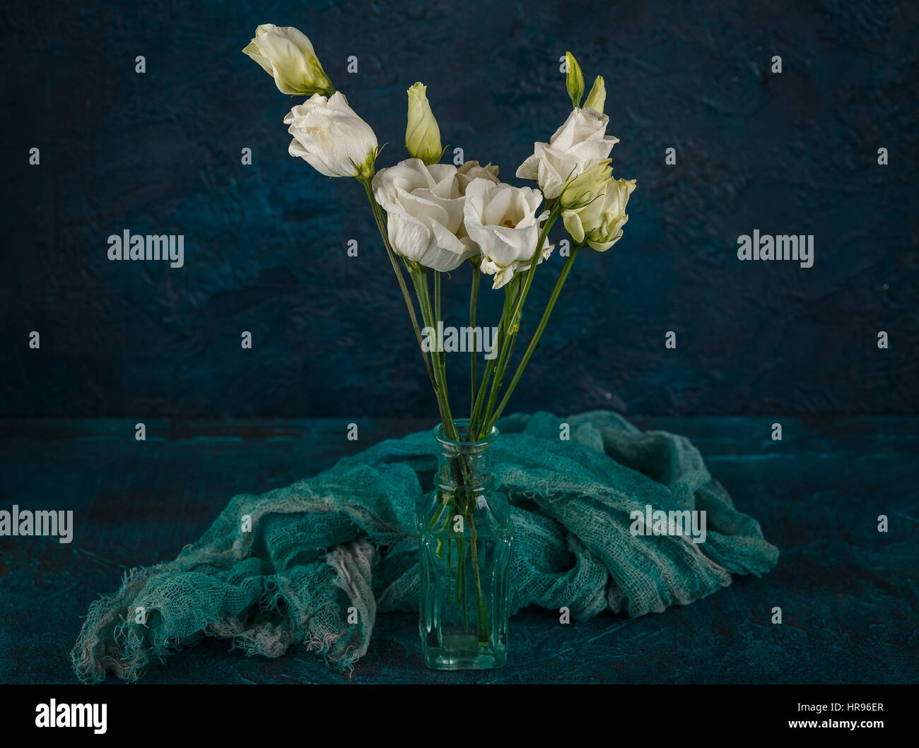 Bouquet di eustoma bianco fiori in vasi di vetro su sfondo blu scuro Foto Stock