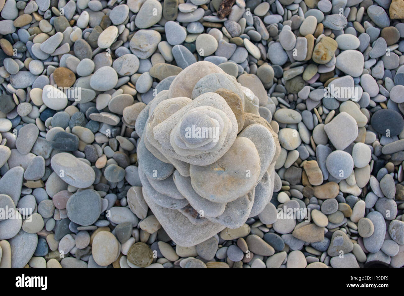 Piramide piegata Zen pietre ghiaia sul mare spiaggia al tramonto Foto Stock