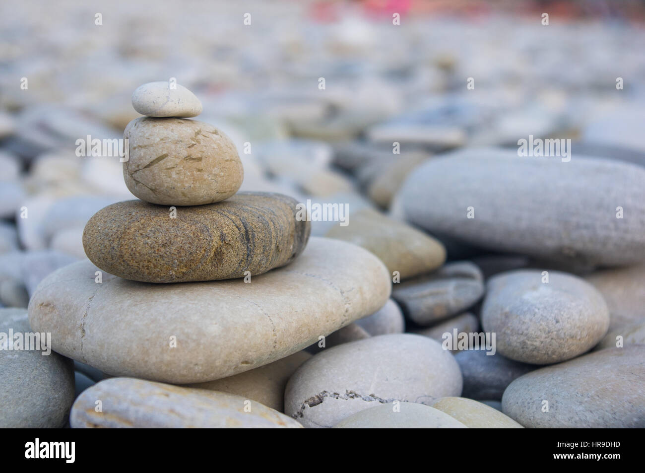 Piramide piegata Zen pietre ghiaia sul mare spiaggia al tramonto Foto Stock
