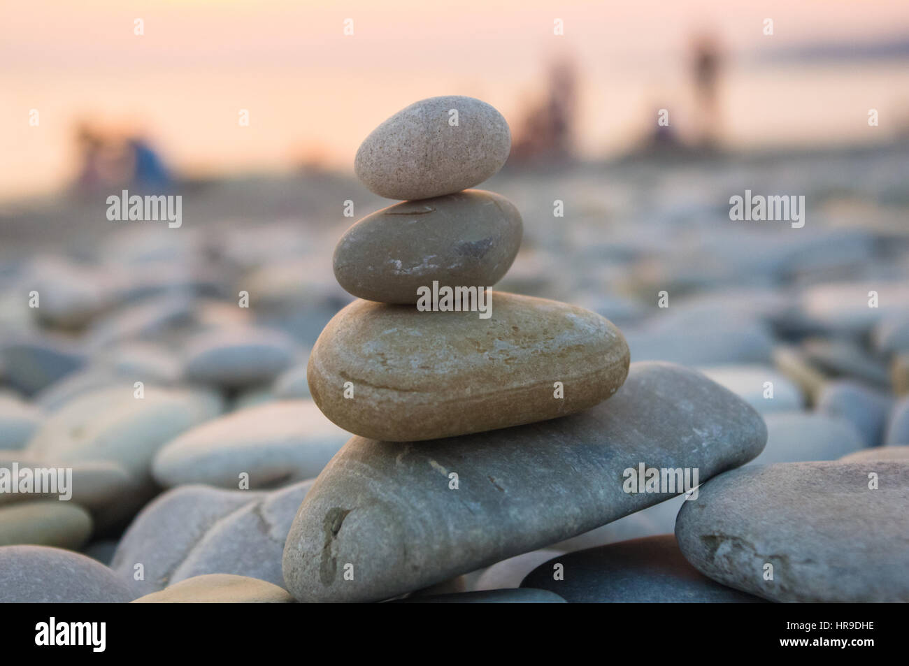Piramide piegata Zen pietre ghiaia sul mare spiaggia al tramonto Foto Stock