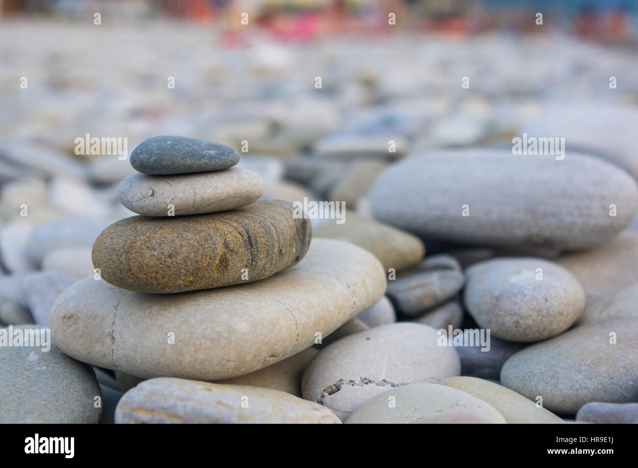 Piramide piegata Zen pietre ghiaia sul mare spiaggia al tramonto Foto Stock