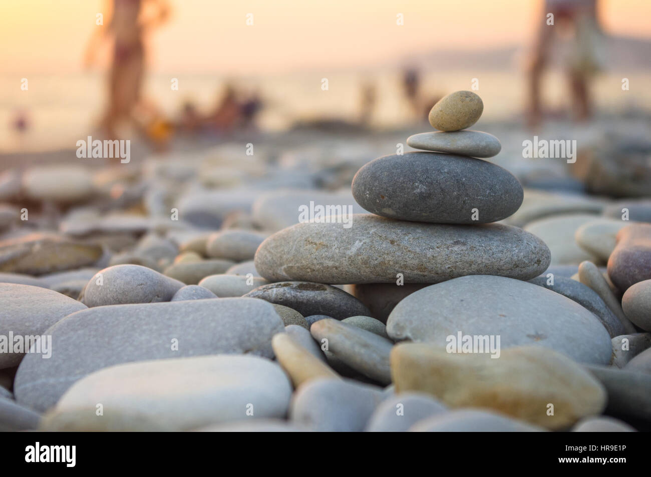 Piramide piegata Zen pietre ghiaia sul mare spiaggia al tramonto Foto Stock
