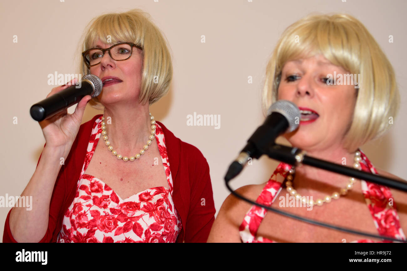 Cantanti femminili di una band locale - Out of the Shadows - eseguono canzoni popolari degli anni '1960 in un evento organizzato dal comune di Farnham. Foto Stock