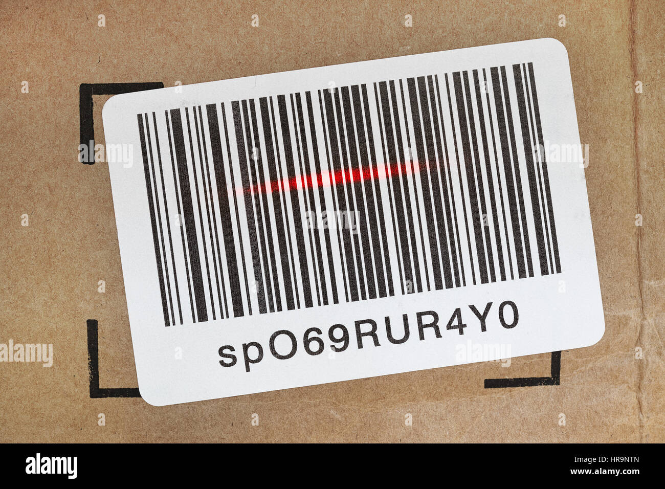 Etichetta con codice a barre sulla scatola di spedizione in fase di scansione rosso con dispositivo laser. Foto Stock