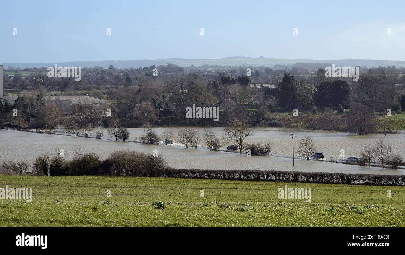 Automobili in marcia su una strada inondata dal fiume Avon traboccante le sue banche, Staverton, vicino Trowbridge, Wiltshire, Regno Unito, febbraio 2014. Foto Stock