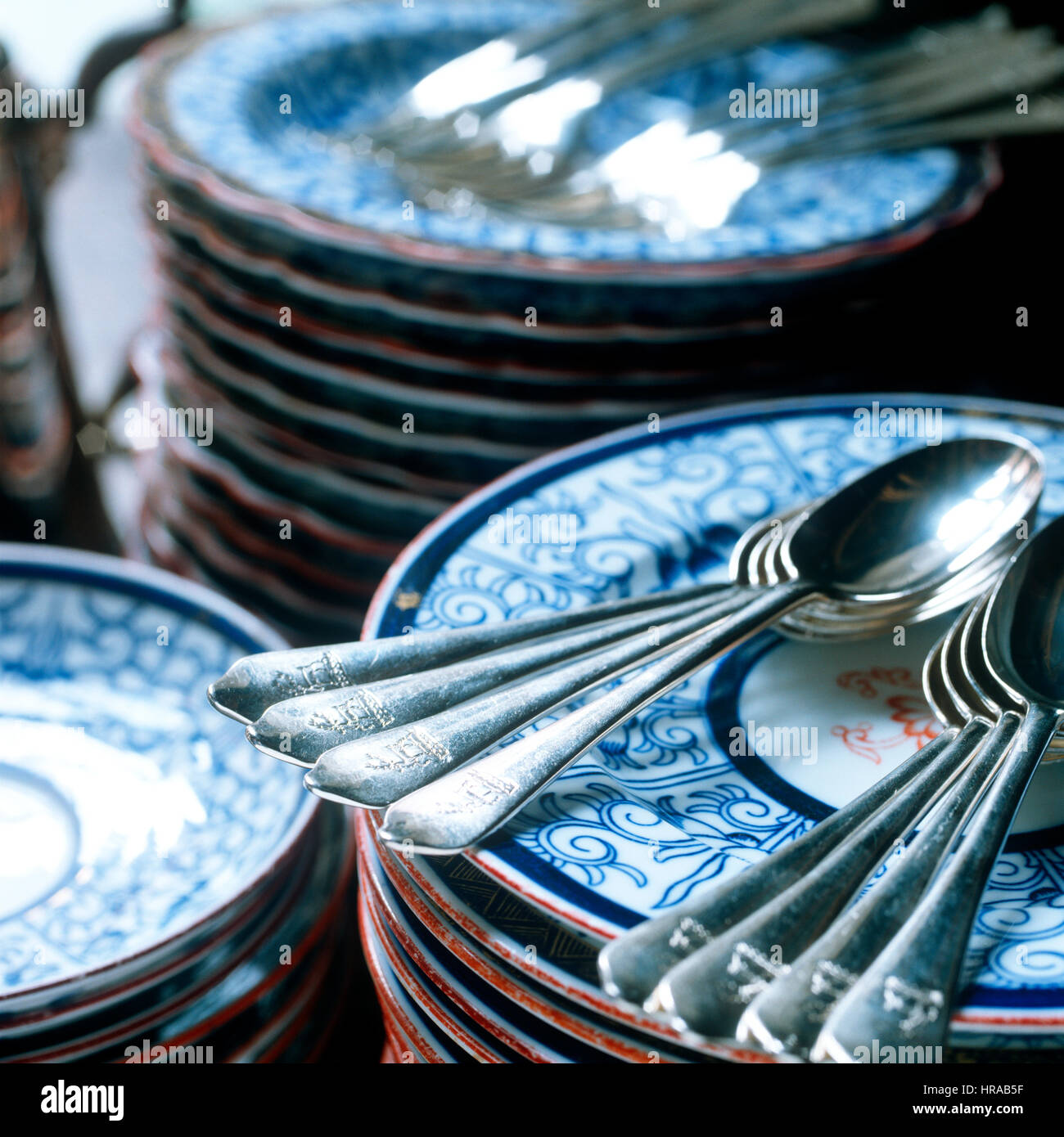 Cucchiaini in argento inciso con stemma di famiglia sul blu e le piastre bianche Foto Stock