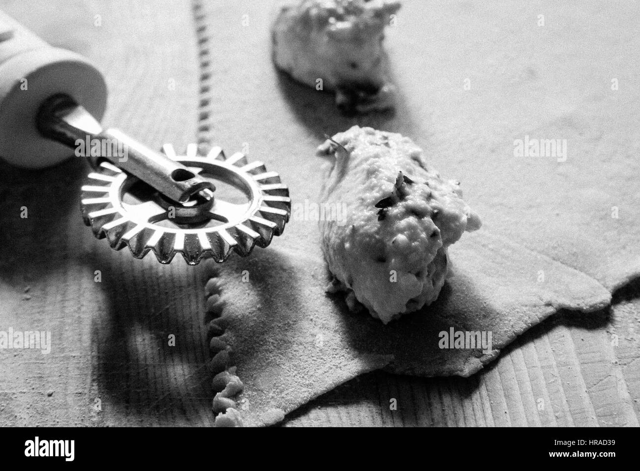 Close up di preparazione dei ravioli di pasta che mostra la ricotta basato il riempimento e la pasta a casa in Italia con pasta corrugata taglierina; cucina casalinga Foto Stock