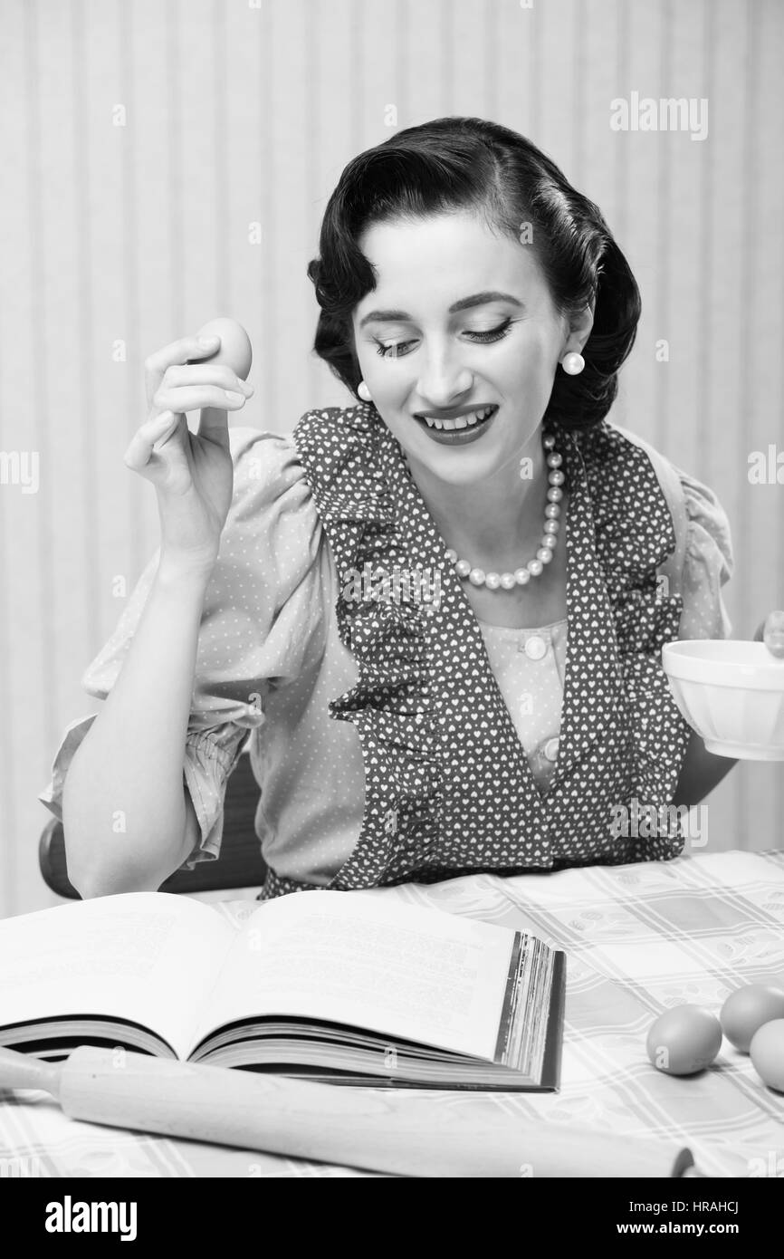 Giovane donna alla ricerca di una ricetta per una torta Foto Stock