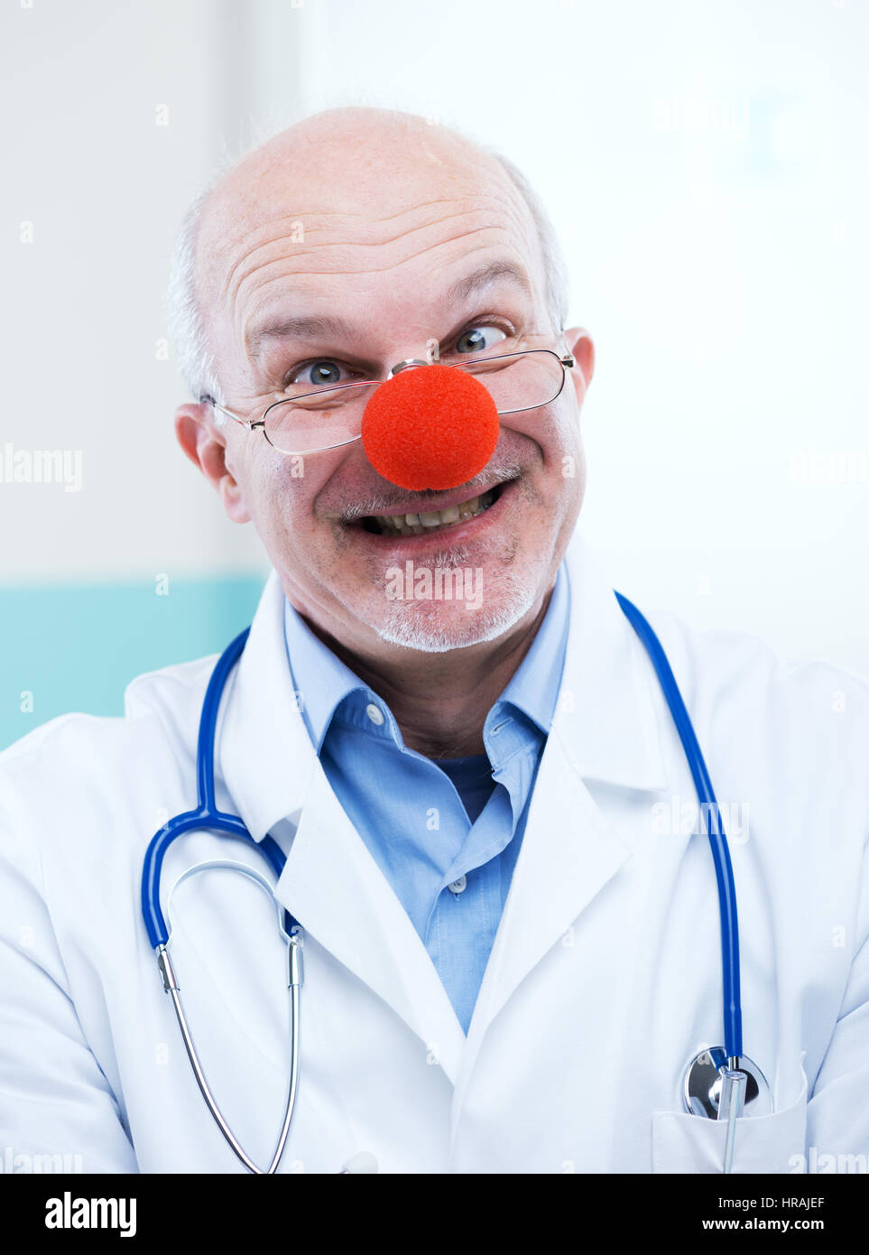 Funny senior medico con red clown naso e espressione divertente. Foto Stock