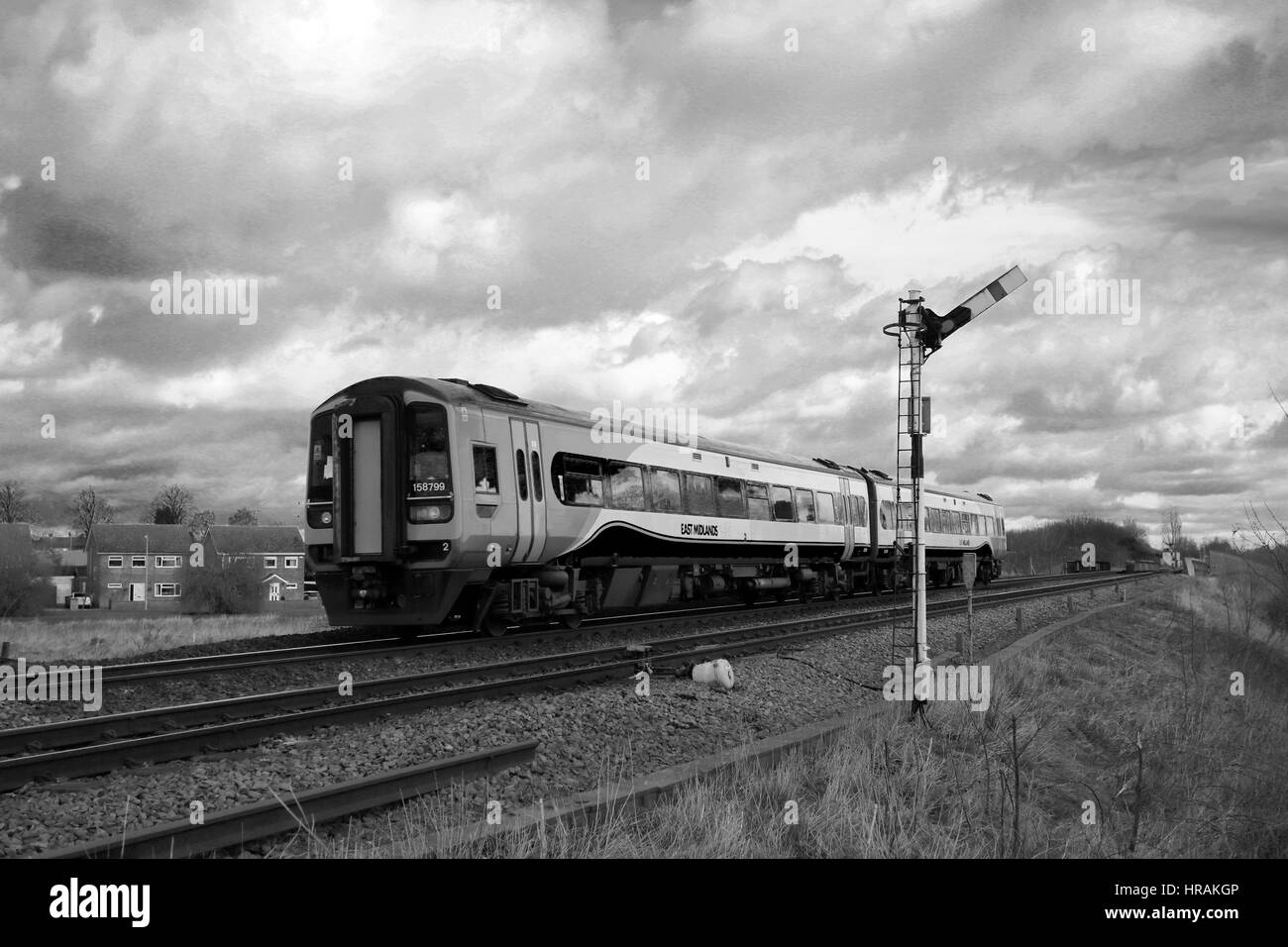 East Midlands treni, 158799 passando un livello senza equipaggio crossing, whittlesey town, fenland, Cambridgeshire, Inghilterra. Foto Stock