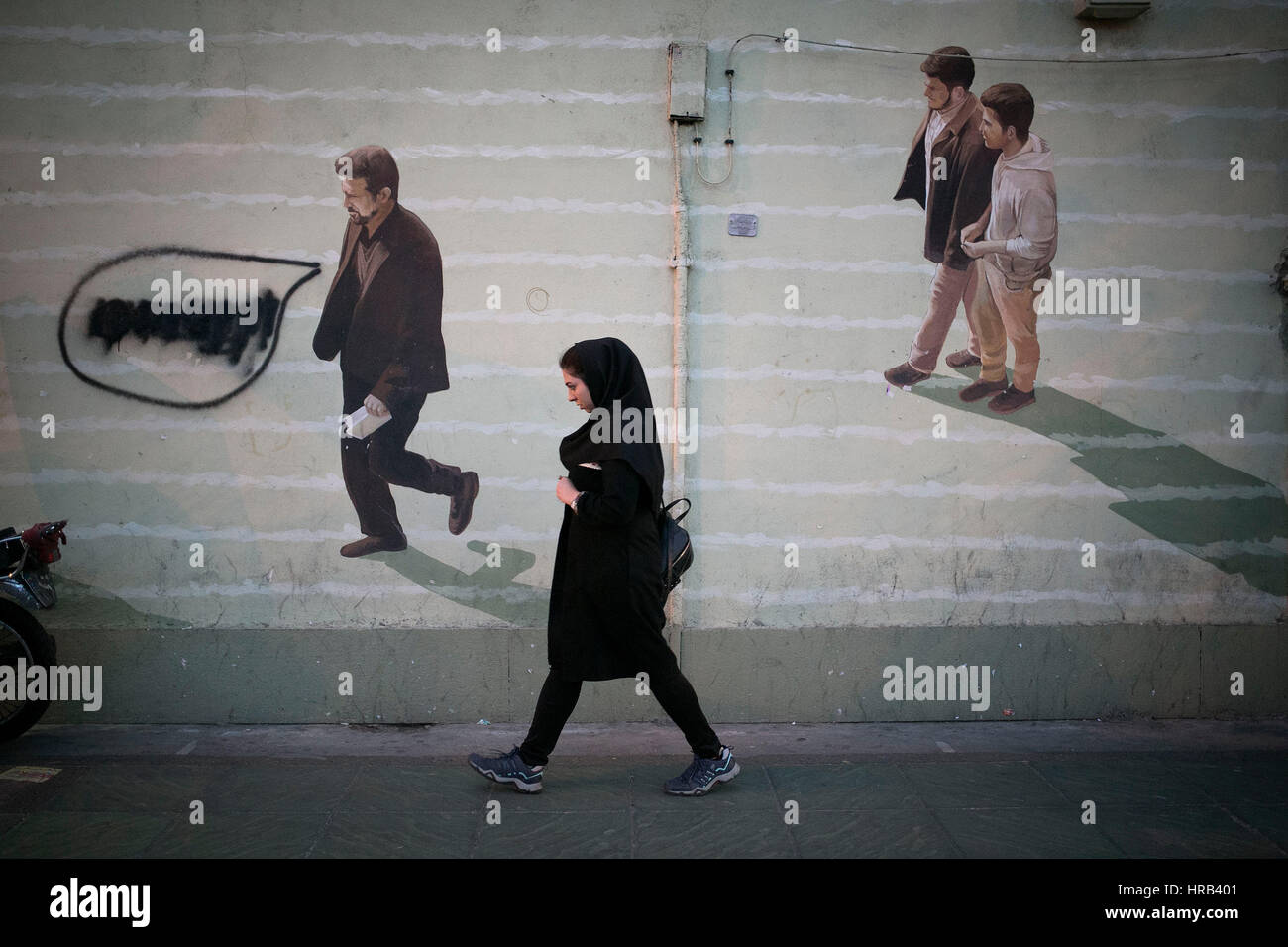 Tehran, Iran. 28 Feb, 2017. Una donna cammina passato un graffiti nel centro di Teheran, capitale dell'Iran, 28 febbraio, 2017. Credito: Ahmad Halabisaz/Xinhua/Alamy Live News Foto Stock