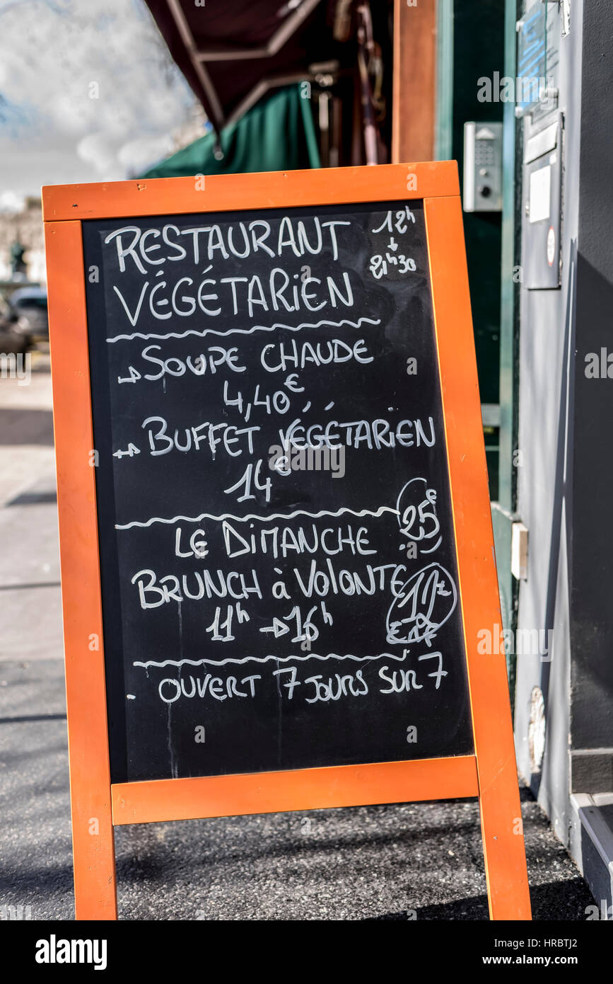 Un bistro Francese segno di menu su una lavagna scritta in bianco gesso su un cavalletto di arancione.Si riscontra in Parigi Francia. Foto Stock