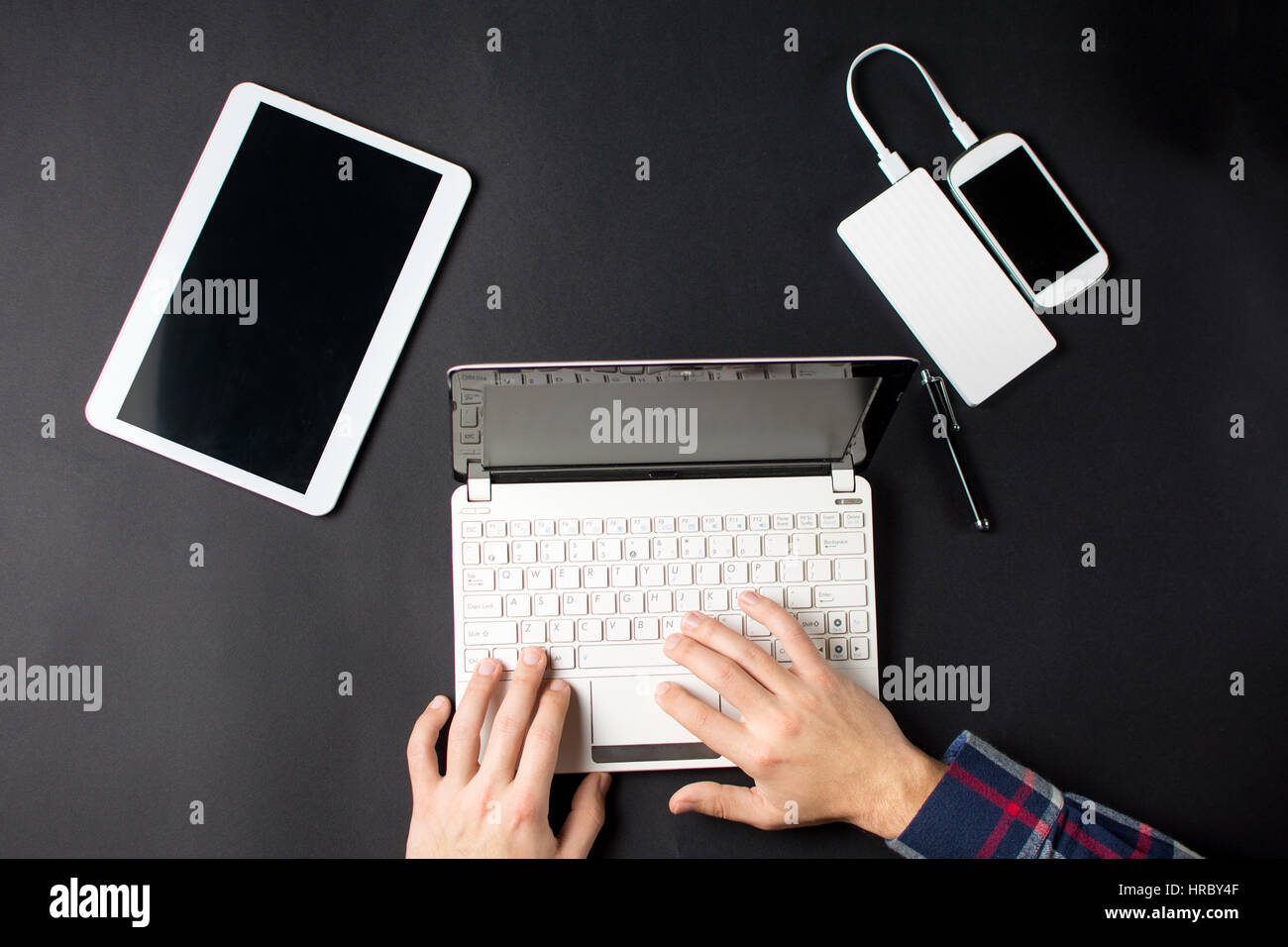 Uomo che utilizza un bianco lap top su nero Foto Stock