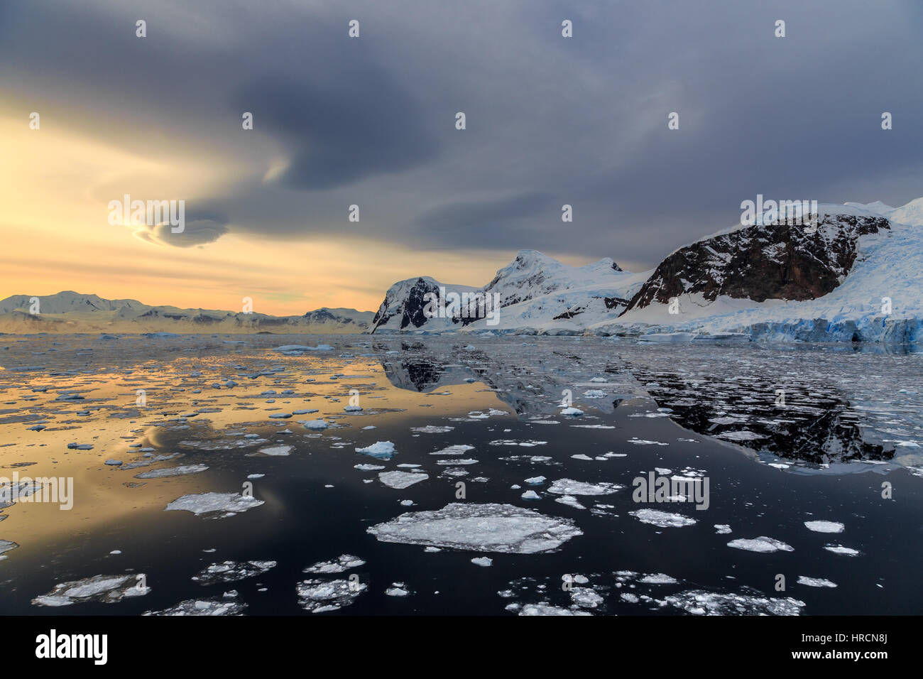 Tramonto sulle montagne e vaganti iceberg presso Lemaire stretto, Antartide Foto Stock