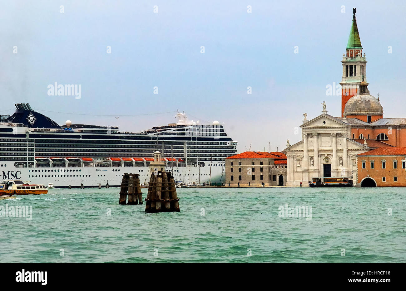 Venezia, Italia : una grande nave attraverso la laguna inizia. Venezia, famosa per la sua serena canali, è una grande destinazione per crociere nel Mediterraneo. Ogni anno circa 600 "grandi navi" passano attraverso il canale della Giudecca, trattando i passeggeri alle viste del xv secolo Palazzo Ducale e Piazza San Marco. Ma i critici dicono che la floating bestioni sono esteticamente nocivo, e la preoccupazione che una catastrofe come il naufragio della Costa Concordia potrebbe danneggiare irreparabilmente la città antica architettura. Foto Stock