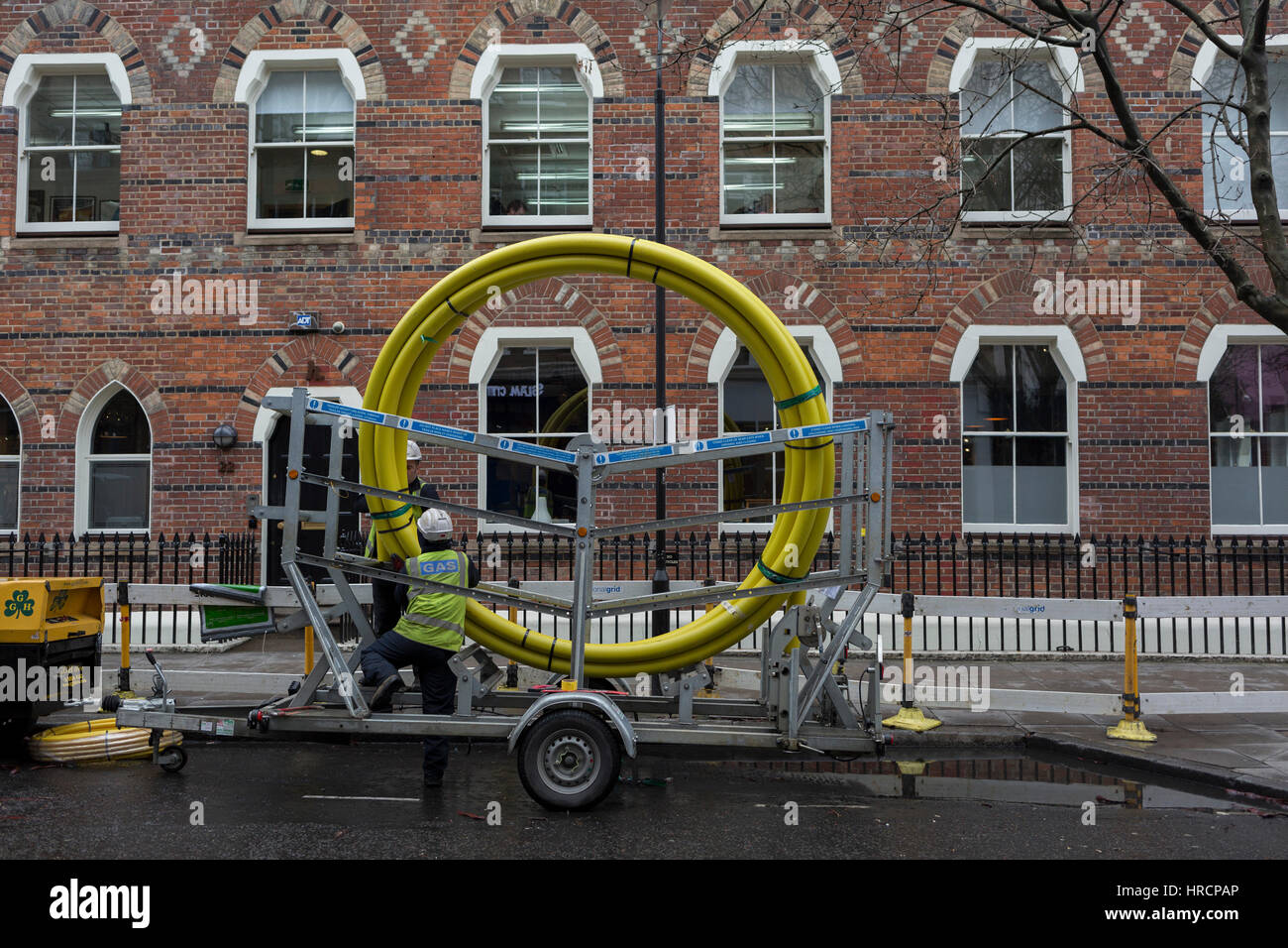 Un fornitore di gas uncoils collari tubazioni da un aspo gigante, il 28 febbraio 2017, a Londra, in Inghilterra. Foto Stock