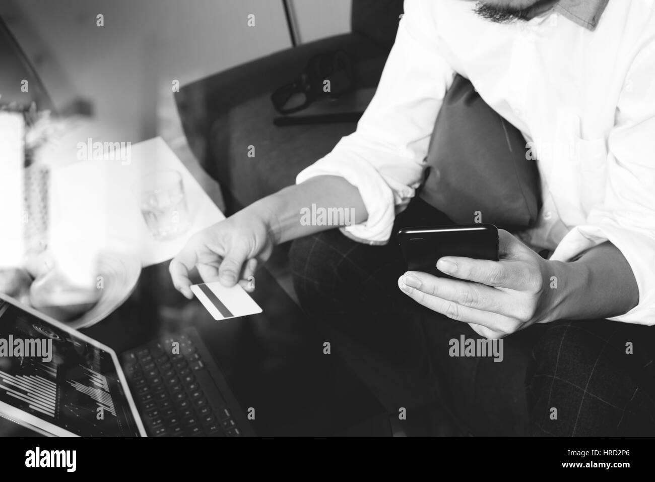 Hipster mano utilizzando smart phone e laptop compter,azienda cradit pagamenti effettuati con carta di credito online business,seduto sul divano nel soggiorno,mele verdi in legno t Foto Stock