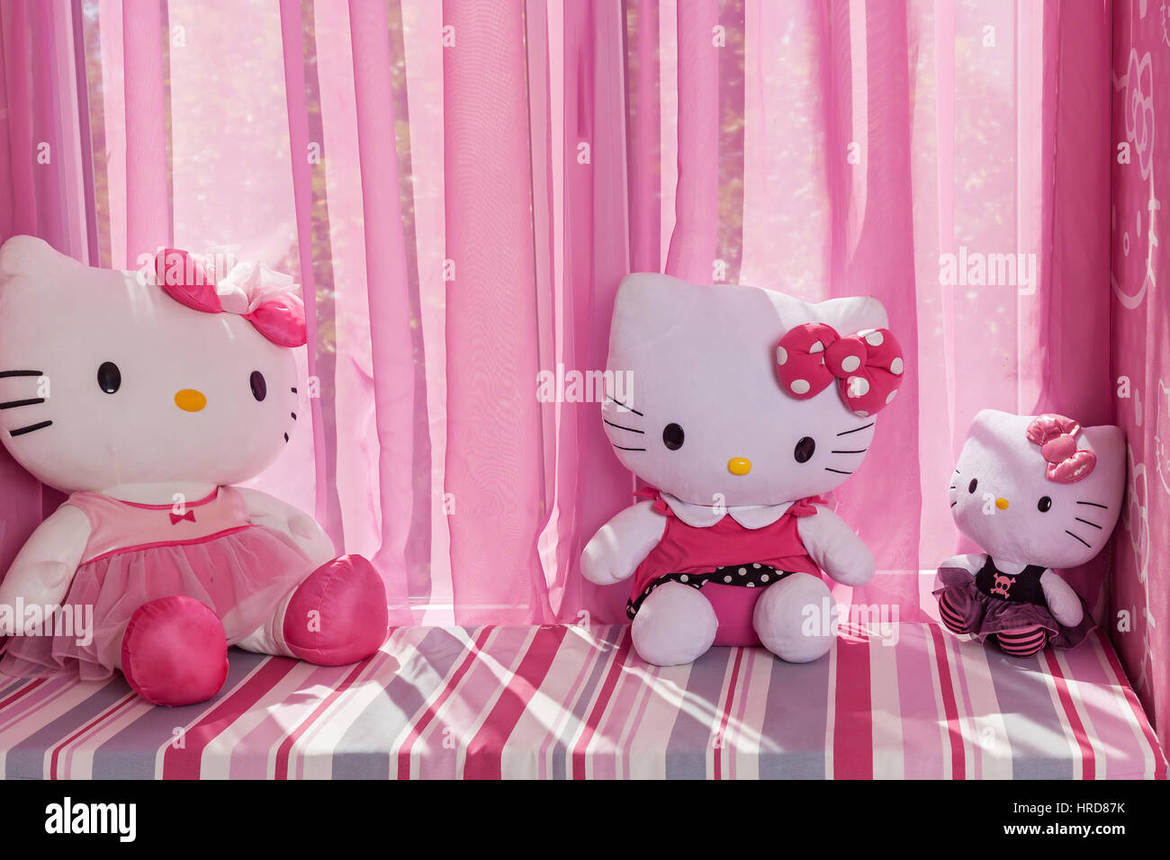 La Russia è Taganrog 13.07.2016 tre diverse dimensioni dei giocattoli Hello Kitty giacente sulla finestra contro il design di colore rosa. Foto Stock